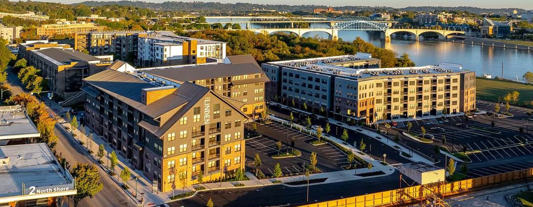 aerial view of a community with a bridge over water in the background