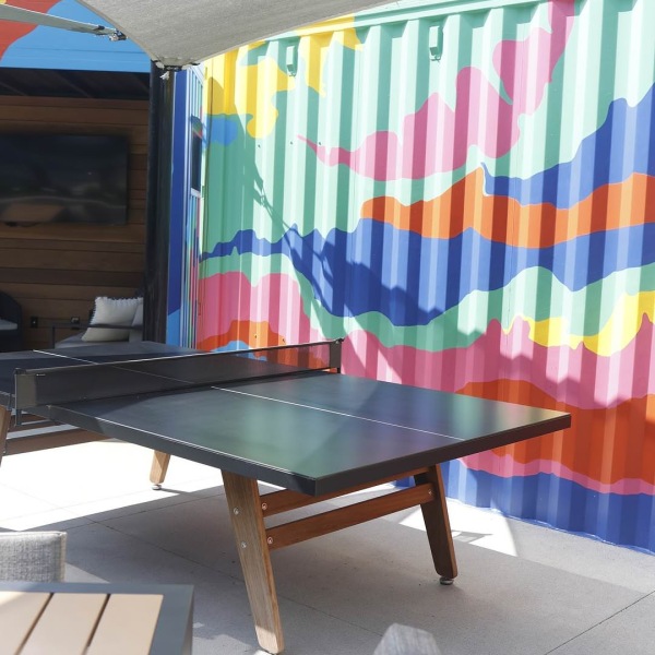 The essence of exceptional living a ping pong table outside next to a colorful wall