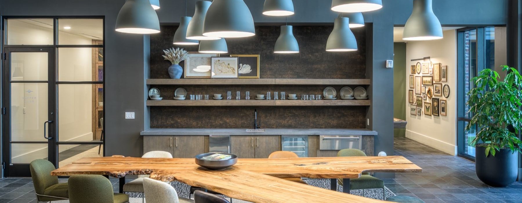 a lounge with seating wood table and a kitchen